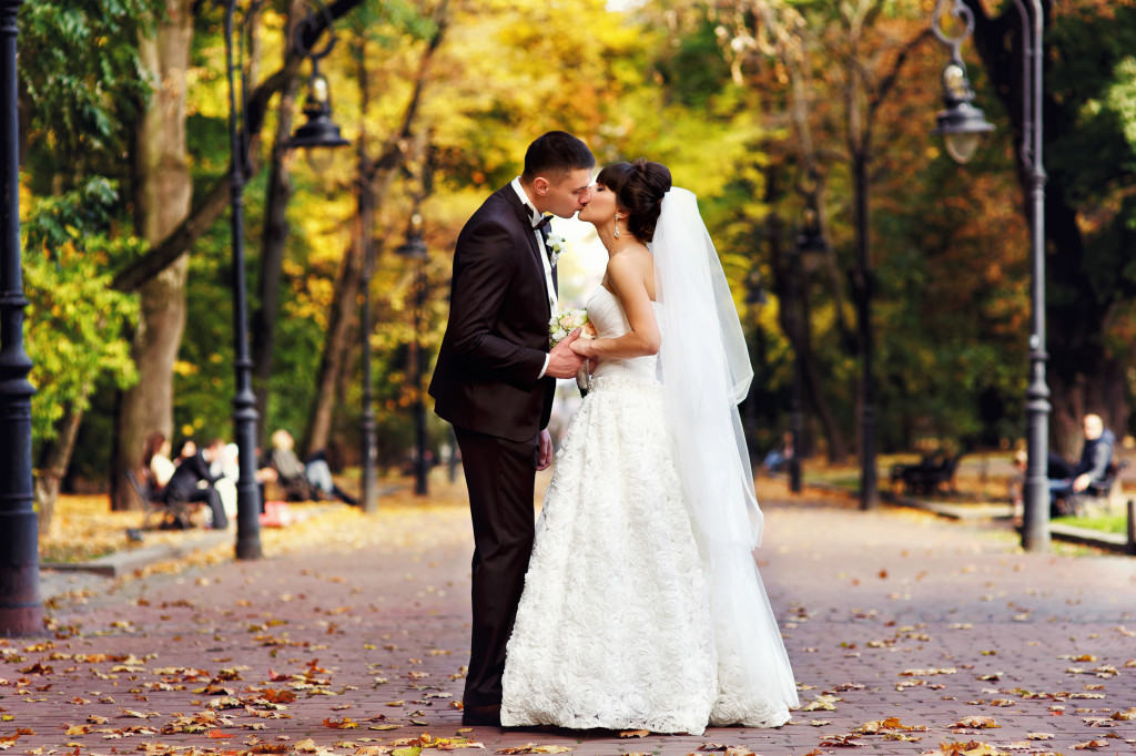 wedding couple standing in autumn park alley