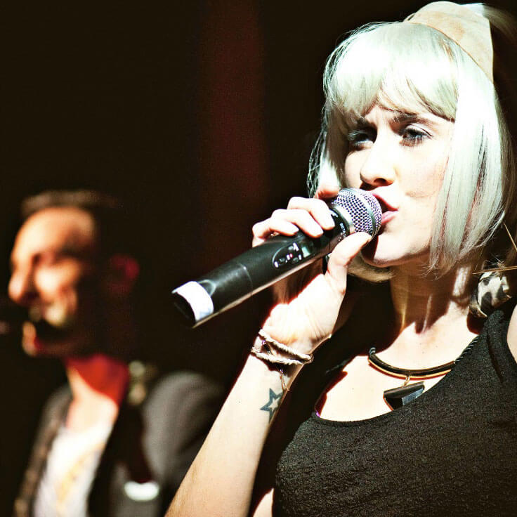 Female performer singing alongside male vocalist.