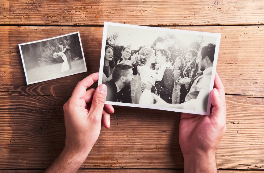 Wedding photos laid on a table. Studio shot on wooden background.