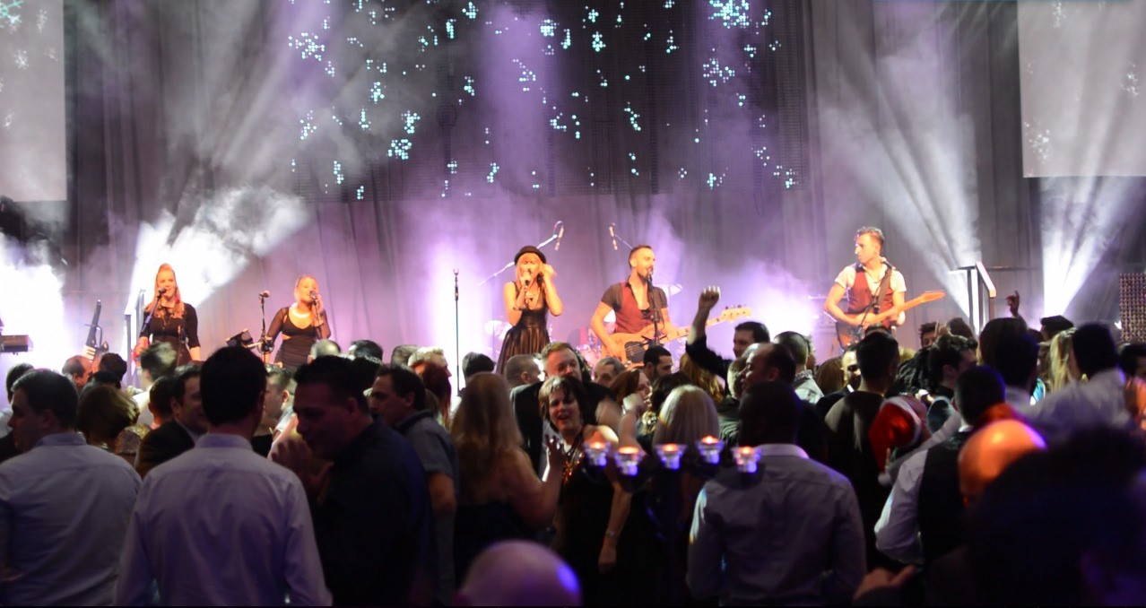 the talent band on stage, people cheering in the foreground.